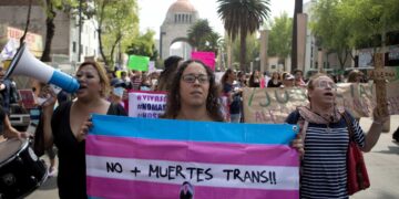 A demonstrator holds a flag that says in Spanish "No more trans deaths!" to protest violence against the transgender community in Mexico City, Thursday, Oct. 20, 2016. Protesters denounced the murders of several transgender people who were killed last week in Mexico City. (AP Photo/Eduardo Verdugo)