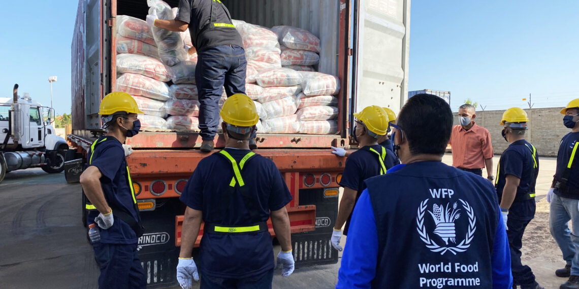 At the WFP logistics hub of Maracaibo, Venezuela, a WFP staff supervise the offloading of  food bags from the the first WFP convoy to arrive in the country.  The arrival of the food kick starts WFP's new school meals programme in Venezuela. The food will initially be distrbuted as take-home rations to the families of school children under the age of 6 and their school's personnel in parts of the country most affected by food insecurity.