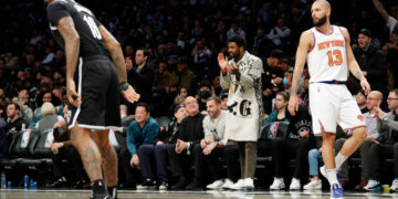 NEW YORK, NEW YORK - MARCH 13: Kyrie Irving of the Brooklyn Nets (C) claps as James Johnson #16 of the Brooklyn Nets and Evan Fournier #13 of the New York Knicks play during the second half at Barclays Center on March 13, 2022 in the Brooklyn borough of New York City. The Nets won 110-107. NOTE TO USER: User expressly acknowledges and agrees that, by downloading and or using this photograph, User is consenting to the terms and conditions of the Getty Images License Agreement. (Photo by Sarah Stier/Getty Images)