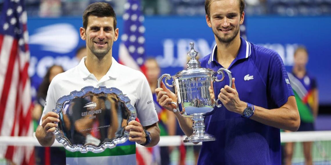 NEW YORK, NEW YORK - SEPTEMBER 12: Novak Djokovic of Serbia holds the runner-up trophy alongside Daniil Medvedev of Russia who celebrates with the championship trophy after winning their Men's Singles final match on Day Fourteen of the 2021 US Open at the USTA Billie Jean King National Tennis Center on September 12, 2021 in the Flushing neighborhood of the Queens borough of New York City.  (Photo by Matthew Stockman/Getty Images)