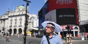 Un hombre se cubre con sombrilla en Londres, Reino Unido. EFE/EPA/NEIL HALL