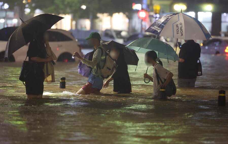 La gente vadea un camino inundado en el sur de Seúl, Corea del Sur, el 8 de agosto de 2022. EFE/EPA/YONHAP