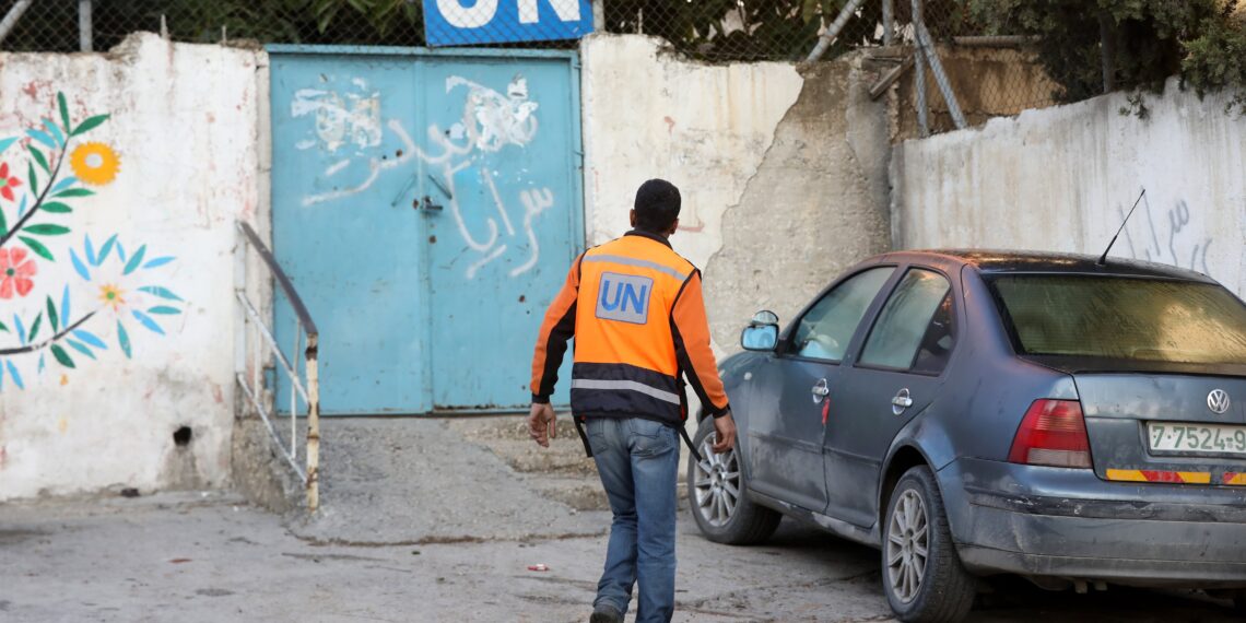 Un trabajador de la Agencia de la ONU para los Refugiados de Palestina (UNRWA) frente al acceso a las instalaciones de la ONU dentro del campo de refugiados de Balata, cerca de la ciudad palestina de Nablus, en una foto de archivo. EFE/ Alaa Badarneh