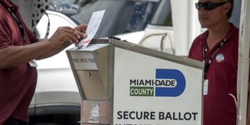 Diputados electorales ayudan a los votantes a depositar su papeleta de voto por correo en el Buzón Oficial de Boletas de las Primarias de Florida de 2022 en Miami, este 23 de agosto de 2022. EFE/EPA/Cristóbal Herrera-Ulashkevich