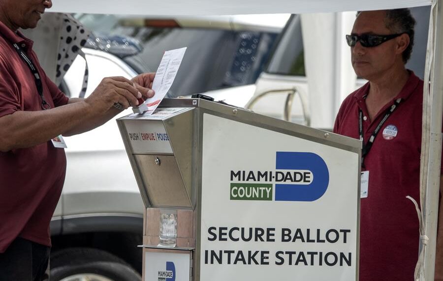 Diputados electorales ayudan a los votantes a depositar su papeleta de voto por correo en el Buzón Oficial de Boletas de las Primarias de Florida de 2022 en Miami, este 23 de agosto de 2022. EFE/EPA/Cristóbal Herrera-Ulashkevich