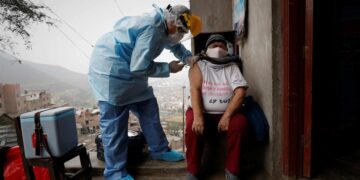 Un enfermero de la posta médica del Cerro El Agustino coloca a un residente una vacuna en Lima (Perú). Imagen de archivo. EFE/Paolo Aguilar