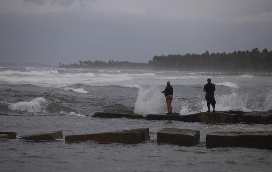 Dos personas pescan en la playa hoy, mientras el país se prepara para el paso en las próximas horas del huracán Fiona, en Nagua (República Dominicana). EFE/Orlando Barría