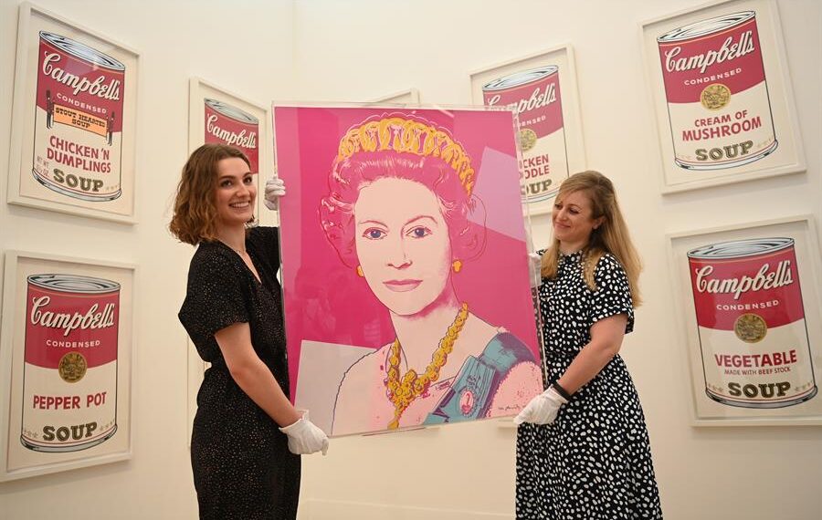 Trabajadoras de la la Phillips Gallery de Londres posan con la obra "Queen Elizabeth II of the United Kingdom (1985)", del artista estadounidense Andy Warhol, el pasado 1 de junio. EFE/EPA/NEIL HALL