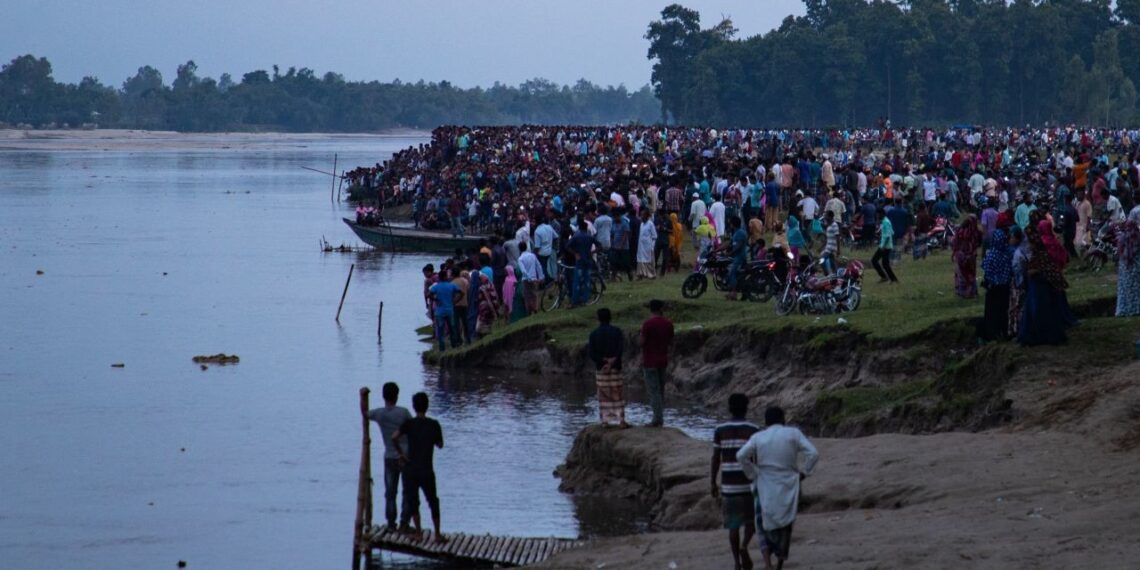 Varias personas se reúnen a las orillas del río para ver los trabajos de rescate (Créditos: AFP)