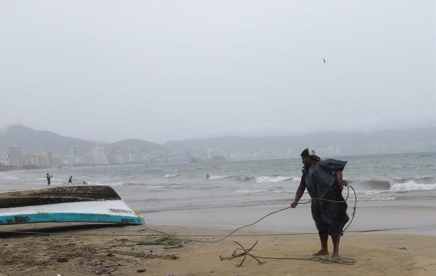 Un hombre retira un bote de las aguas en el balneario de Acapulco (México). Imagen de archivo. EFE/ David Guzmán