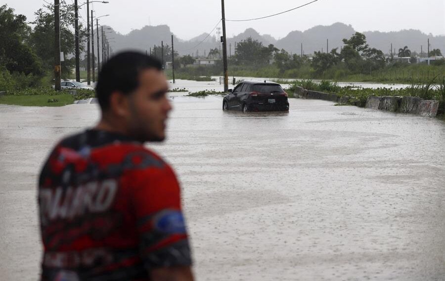 Un hombre observa un automóvil en una calle inundada debido a lluvias ocasionadas por el paso del huracán Fiona, el 19 de septiembre de 2020, en Toa Baja (Puerto Rico). EFE/Thais Lorca