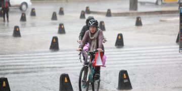 Fotografía de archivo de dos personas que se transportan en bicicleta bajo las intensas lluvias que afectan a la Ciudad de México (México). EFE/Sáshenka Gutiérrez