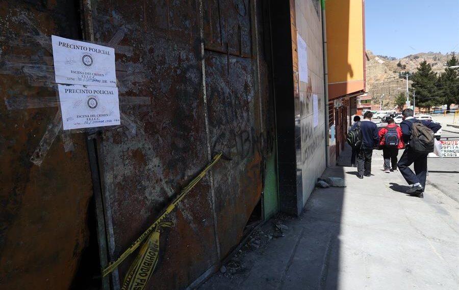 Estudiantes pasan por las puertas del llamado "mercado paralelo" que fue incendiado por los cocaleros de Adepcoca durante una vigilia por la materia prima destruida la semana pasada hoy, en La Paz (Bolivia). EFE/ Martín Alipaz