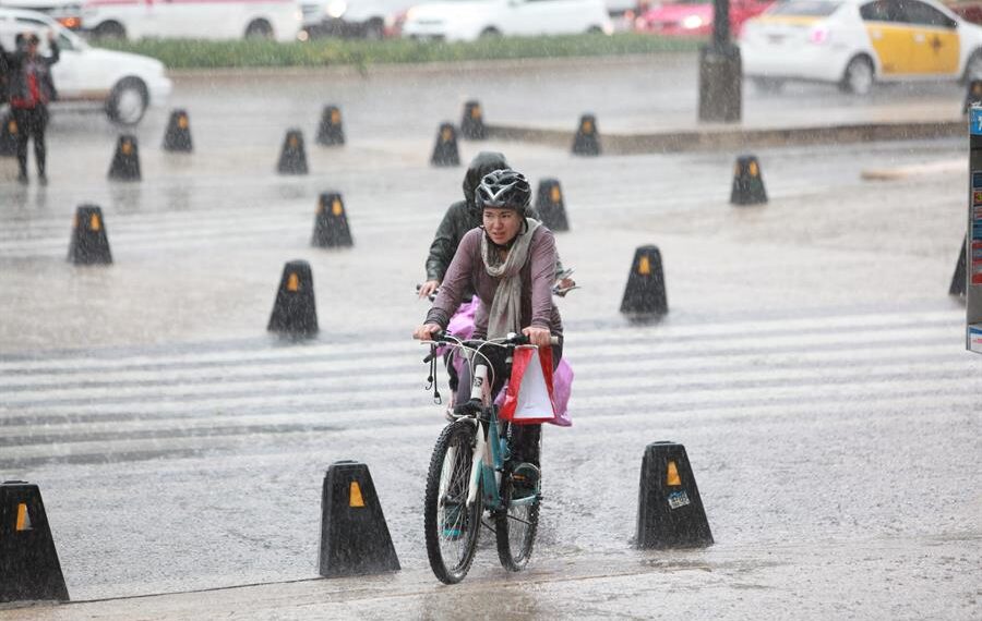 Fotografía de archivo de dos personas que se transportan en bicicleta bajo las intensas lluvias que afectan la Ciudad de México (México). EFE/Sáshenka Gutiérrez