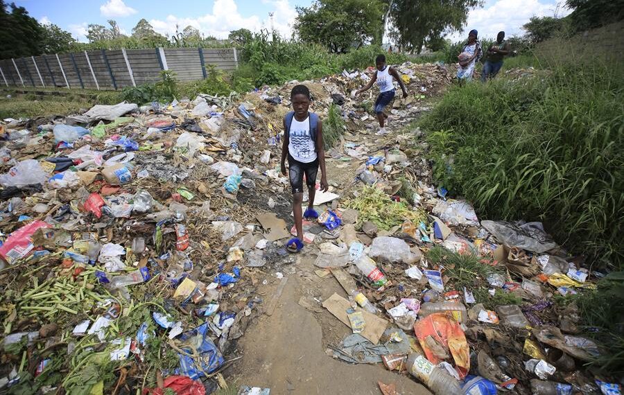 En la imagen de archivo, varios niños pasean por una zona de basuras en Zimbabue. EFE/EPA/AARON UFUMELI