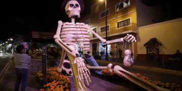 Visitantes observan una figura de calavera gigante, el 20 de octubre de 2022, en las calles del municipio de Atlixco, estado de Puebla (México). EFE/ Hilda Ríos