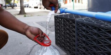 Personas recolectan hoy agua potable en uno de los puntos de abastecimiento en la comuna de Santiago Centro, en Santiago (Chile). EFE/Elvis González