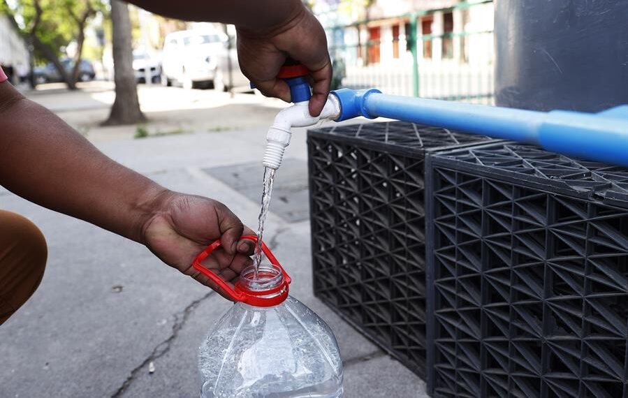 Personas recolectan hoy agua potable en uno de los puntos de abastecimiento en la comuna de Santiago Centro, en Santiago (Chile). EFE/Elvis González