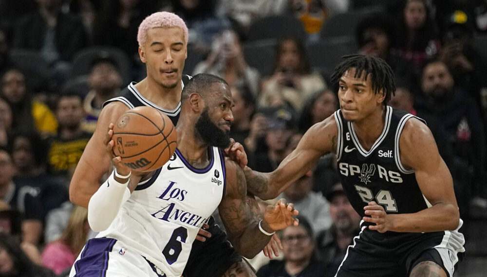 Los Angeles Lakers forward LeBron James (6) drives against San Antonio Spurs forward Jeremy Sochan, left, and guard Devin Vassell (24) during the first half of an NBA basketball game in San Antonio, Saturday, Nov. 26, 2022. (AP Photo/Eric Gay)