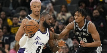 Los Angeles Lakers forward LeBron James (6) drives against San Antonio Spurs forward Jeremy Sochan, left, and guard Devin Vassell (24) during the first half of an NBA basketball game in San Antonio, Saturday, Nov. 26, 2022. (AP Photo/Eric Gay)