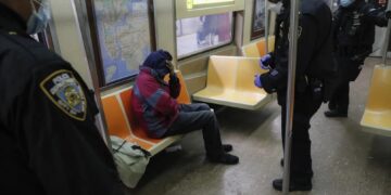 Agentes del Departamento de Policía de Nueva York despiertan a pasajeros dormidos y los dirigen hacia las salidas de la estación de la calle 207 del tren A (AP Photo/John Minchillo, File)