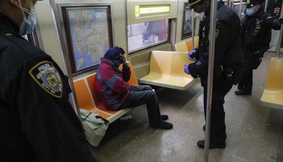 Agentes del Departamento de Policía de Nueva York despiertan a pasajeros dormidos y los dirigen hacia las salidas de la estación de la calle 207 del tren A (AP Photo/John Minchillo, File)