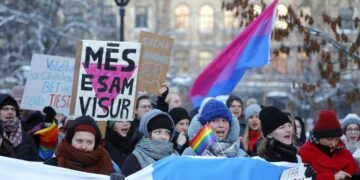 Manifestantes sostienen carteles en favor de las uniones civiles frente al Parlamento de Letonia en Riga este 15 de diciembre. EFE/EPA/TOMS KALNINS