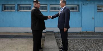 Kim Jong-Un le da la mano al presidente de Corea del Sur, Moon Jae-in, en la Línea de Demarcación Militar que divide a sus países antes de su cumbre en la aldea de la tregua de Panmunjom el 27 de abril de 2018 (Créditos: AFP)