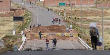 Personas caminan por una calle bloqueada en la frontera de Perú con Bolivia, este 22 de enero de 2022. EFE/Javier Mamani