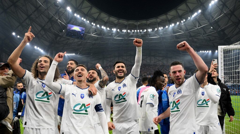 Marseille's players celebrate after winning the French Cup round of 16 football match between Olympique Marseille (OM) and Paris Saint-Germain (PSG) at Stade Velodrome in Marseille, southern France on February 8, 2023. (Photo by NICOLAS TUCAT / AFP)