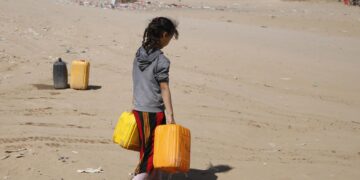 Una niña yemení sostiene recipientes en los que recolectó agua, en una fotografía de archivo. EFE/Yahya Arhab