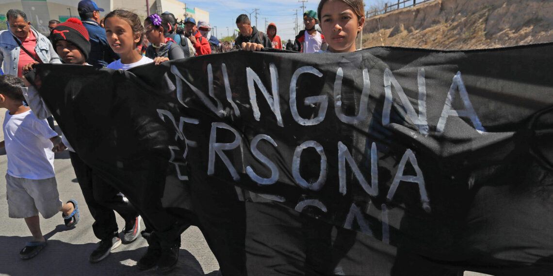 Un grupo de migrantes y activistas protestan durante la llegada del presidente de México Andrés Manuel López Obrador (fuera de cuadro), hoy a Ciudad Juárez, en el estado de Chihuahua (México).  EFE/ Luis Torres