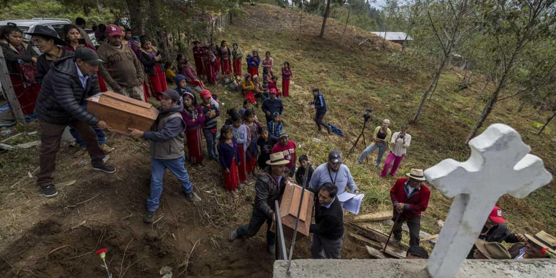 Personas de la comunidad ixil de Jacaná llevan en brazos los féretros de 61 fallecidos durante un entierro masivo, hoy, en Jacaná (Guatemala). EFE/Esteban Biba