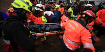Rescatistas trasladan hoy el cuerpo de una niña fallecida en el alud, en Alausí (Ecuador). EFE/José Jácome