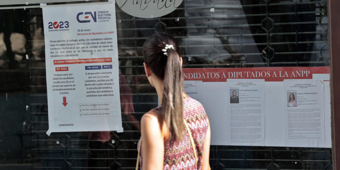 Una joven pasa hoy frente a unos carteles informativos sobre el proceso electoral, en una calle de La Habana (Cuba). EFE/Ernesto Mastrascusa