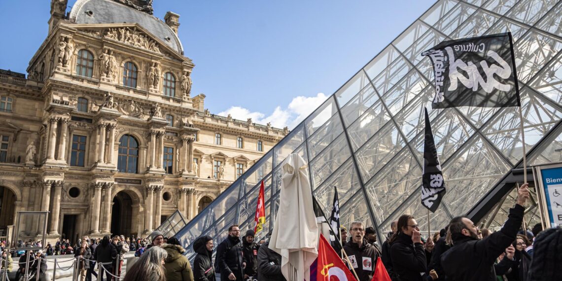Los empleados del Museo del Louvre bloquean la entrada del museo durante una manifestación frente a la Pirámide del Louvre para protestar contra la reforma de las pensiones del gobierno en París, Francia, el 27 de marzo de 2023. EFE/EPA/CHRISTOPHE PETIT TESSON