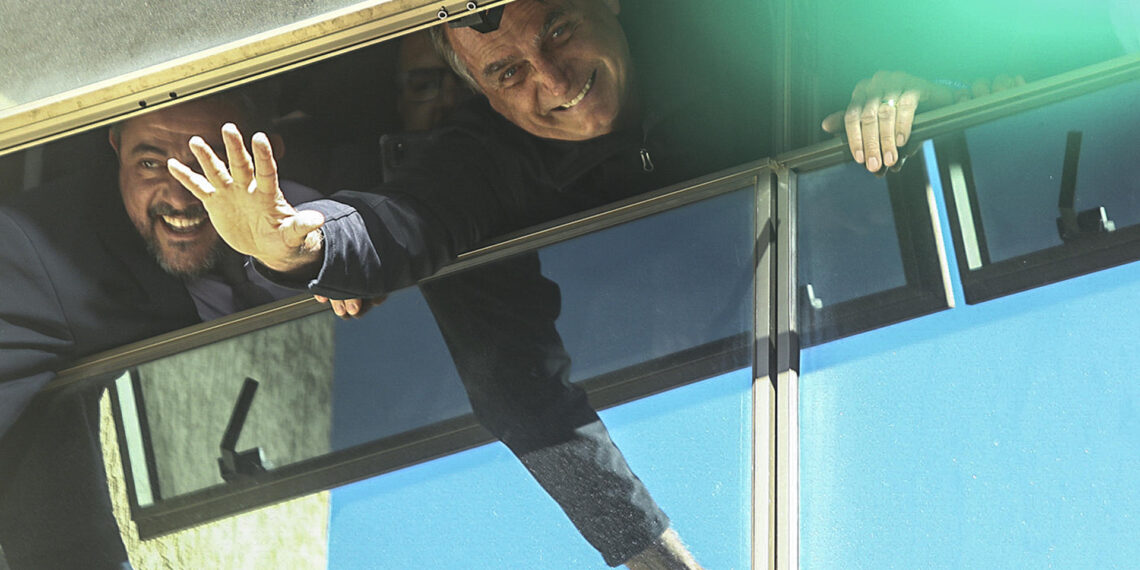 El expresidente de Brasil Jair Bolsonaro fue registrado este jueves, 30 de marzo, al saludar desde una ventana de la sede de su partido, en Brasilia (Brasil). Bolsonaro regresó a Brasil, después de permanecer tres meses en Estados Unidos. EFE/Luís Nova