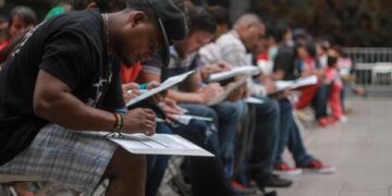 Migrantes llenan solicitudes de trabajo durante la inauguración de una feria del empleo en la ciudad de Tijuana, en el estado de Baja California (Foto: EFE)