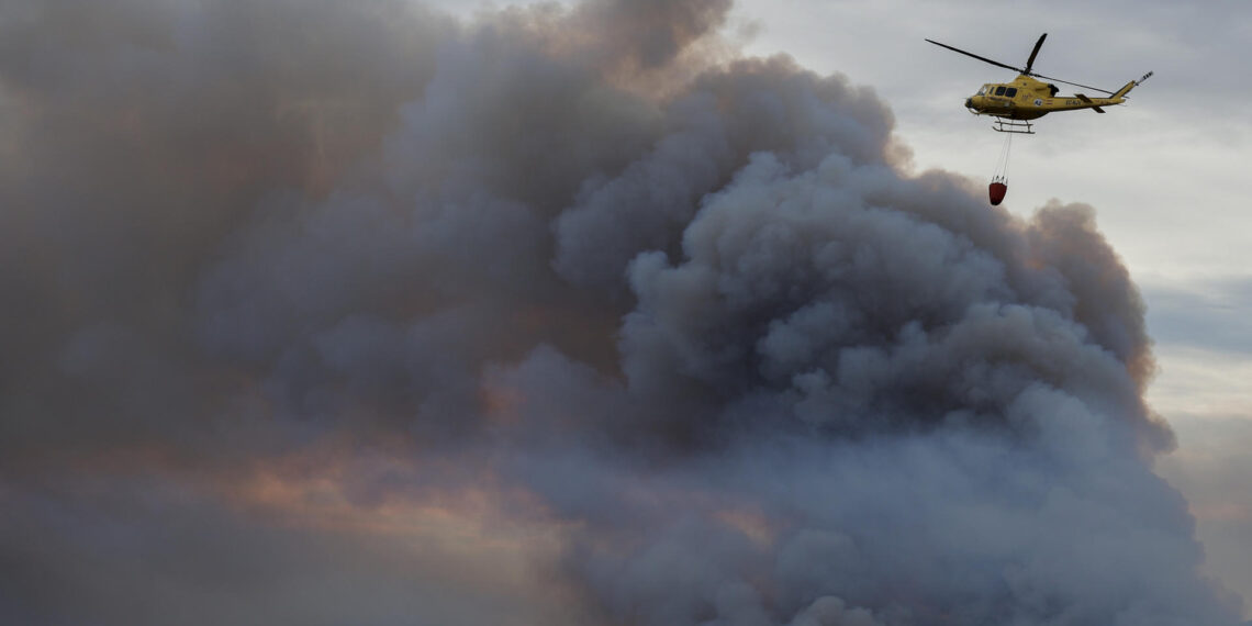Un helicóptero sobrevuela la columna de humo del incendio forestal declarado ayer en el término municipal de Villanueva de Viver, en la zona limítrofe de las provincias de Castellón y Teruel. EFE/Manuel Bruque