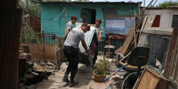 Policías ayudan a recuperar pertenencias en las viviendas de habitantes afectados por el desborde del río Chillón, hoy, en Lima (Perú). EFE/ Paolo Aguilar