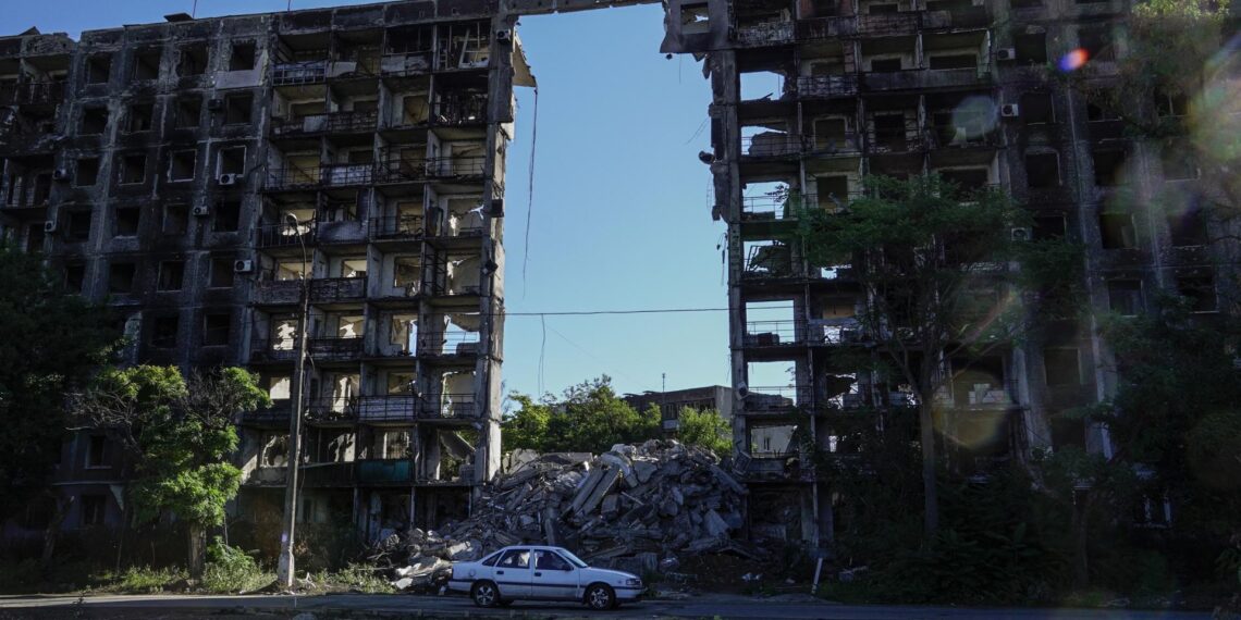 Imagen de archivo de un coche circulando delante de un edificio destrozado en Mariúpol. EFE/EPA/STRINGER