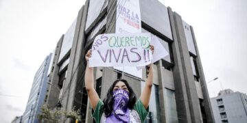 Una mujer alza un letrero en Lima (Perú), en una fotografía de archivo. EFE/Stringer