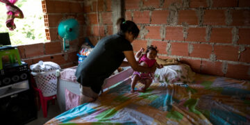 Fotografías de archivo en la que se registró a una mujer al acostar a su hija, quien padece de Malaria, en la ciudad de La Guaira (Venezuela). EFE/Miguel Gutiérrez