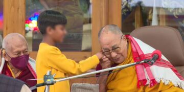 El Dalai Lama, Tenzin Gyatso, tomando la mano de un niño durante un oficio religioso. Captura: Twitter/@NetTibet