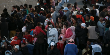 Migrantes se paran detrás de una cerca alambre de púas para evitar que crucen hacia El Paso, Texas, visto desde Ciudad Juárez, México, el 20 de diciembre de 2022. Créditos: Voz de América