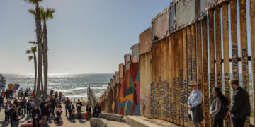 Un grupo de activistas y migrantes participan hoy en una misa en el mirador a un costado muro fronterizo en Playas de Tijuana en Baja California (México).Activistas de México y Estados Unidos se reunieron este Viernes Santo en el muro fronterizo de las playas de Tijuana, para realizar un viacrucis en forma de protesta para señalar las repercusiones que traerán consigo el reemplazo de la valla divisoria que realiza el gobierno estadounidense. EFE/Joebeth Terriquez