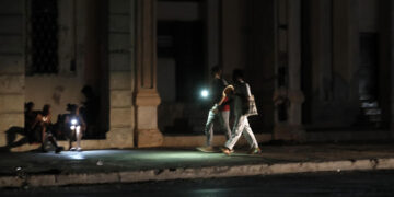 Personas caminan por una calle sin iluminación auxiliándose con la luz de su celular durante un apagón, en La Habana (Cuba). Imagen de archivo. EFE/Ernesto Mastrascusa