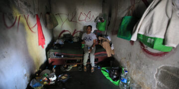 Una migrante muestra sus pertenencias dentro de un edificio abandonado en el que convive con más migrantes el 2 de abril de 2023, en Ciudad Juárez, en el estado de Chihuahua (México). EFE/ Luis Torres