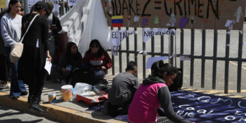 Migrantes escriben pancartas durante una manifestación para exigir justicia por 40 indocumentados que murieron por un incendio hace nueve días, hoy, al exterior del Instituto Nacional de Migración (INM), en Ciudad Juárez (México).  EFE/Luis Torres.