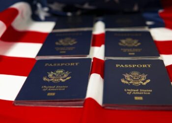 Pasaportes encima de una bandera de EE. UU. Foto: Pixabay/JoshuaWoroniecki.